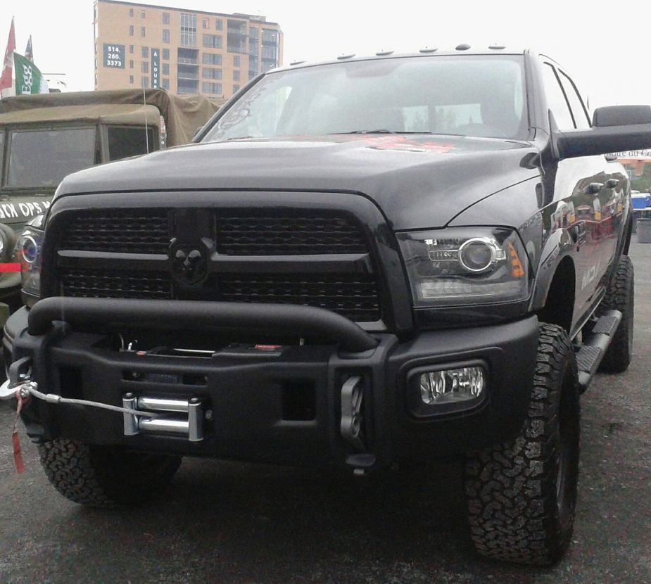 A lifted 2013 Ram 1500 sits in a parking lot.