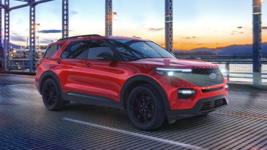 Rapid Red 2023 Ford Explorer midsize SUV driving over a bridge