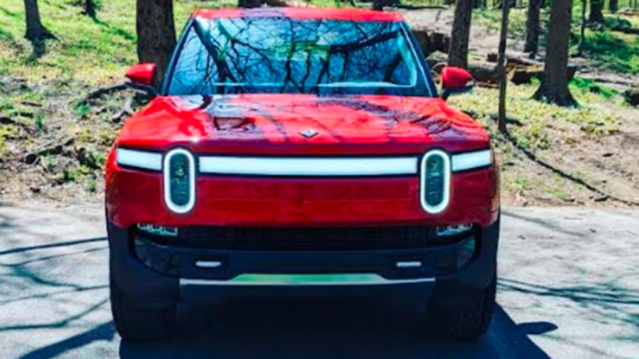 A Canyon Red Rivian R1T Launch Edition is parked.