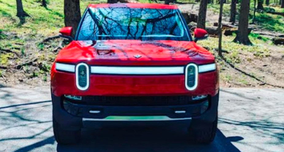 A Canyon Red Rivian R1T Launch Edition is parked. 