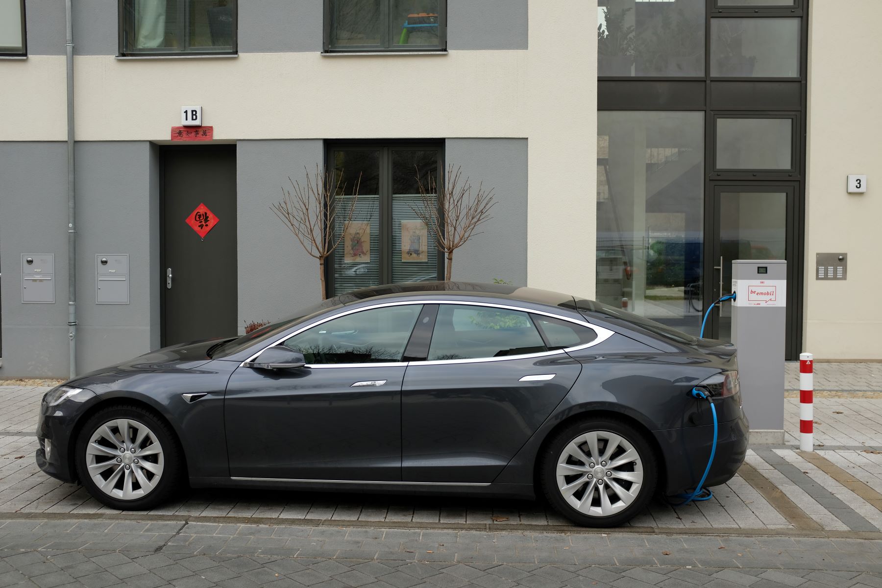 A Tesla Model S electric (EV) luxury full-size sedan charging at a public station in Berlin, Germany