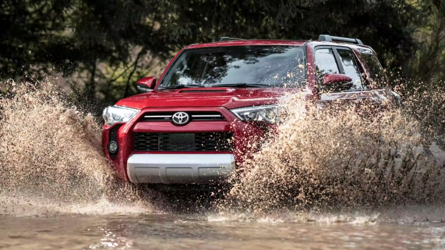 A red 2022 Toyota 4Runner midsize SUV is driving off-road.