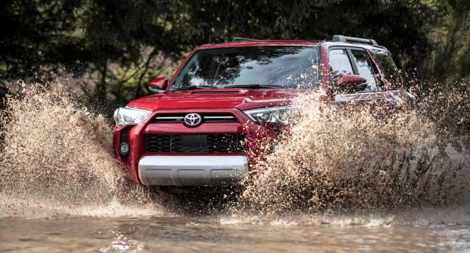 A red Toyota 4Runner midsize SUV is driving off-road.