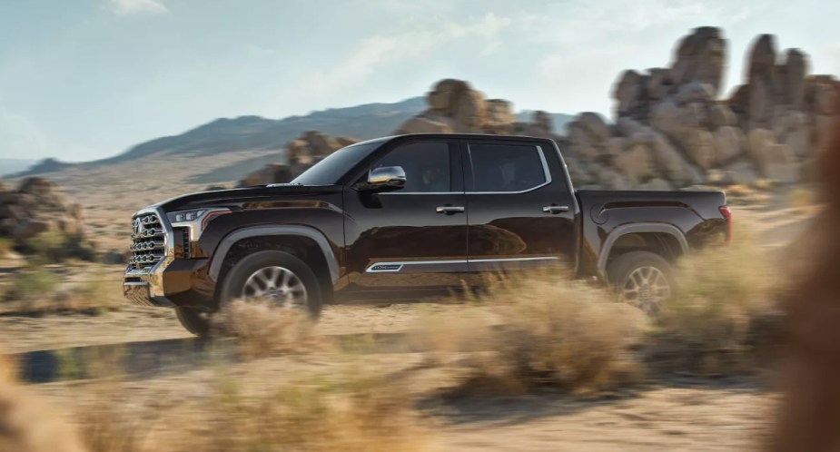 A black 2022 Toyota Tundra full-size pickup truck is driving off-road. 
