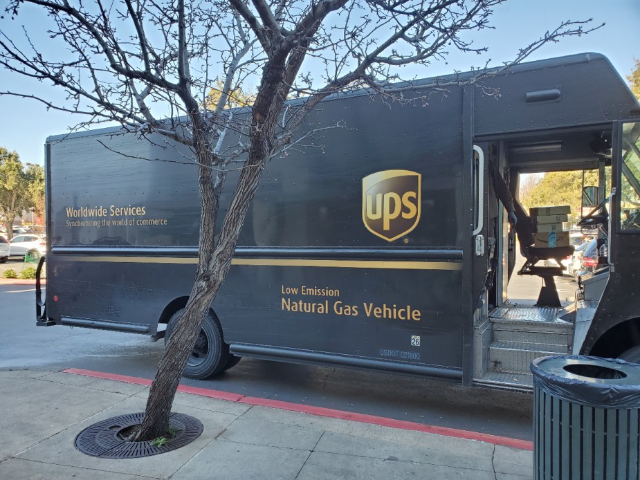 A UPS delivery truck is delivering some Amazon packages.