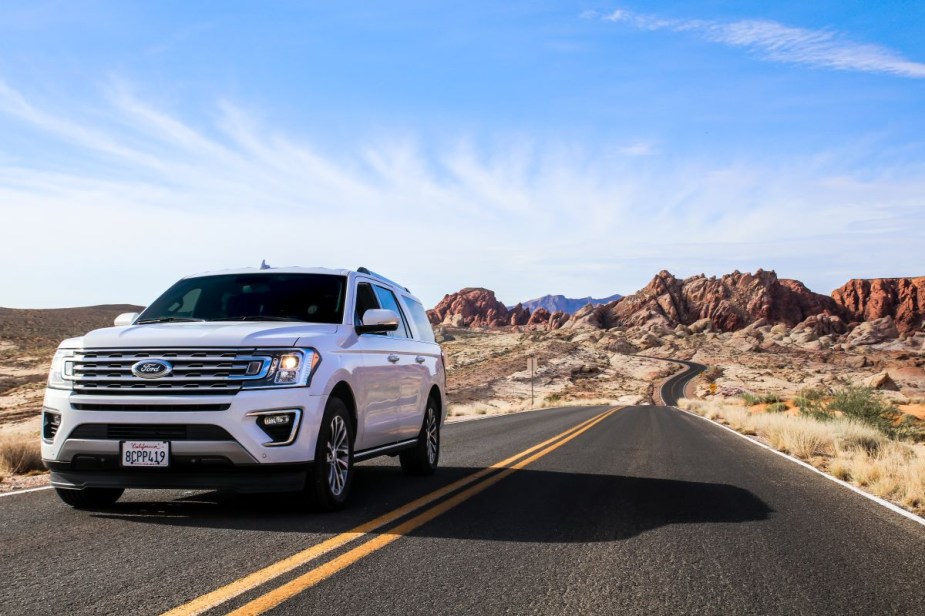 White Ford SUV on a desert highway, highlighting reasons why American cars are so big compared to other countries
