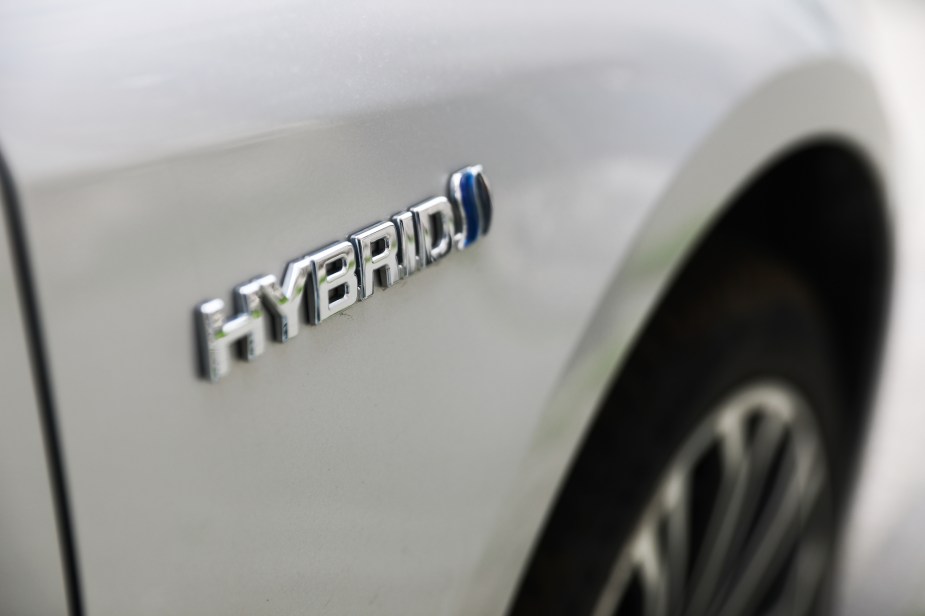 A hybrid car with a hybrid logo on it that is white. 