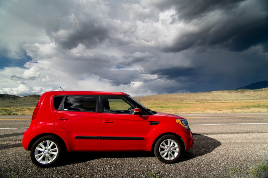 A red Kia Soul on the side of the road.