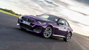 A purple Thundernight Metallic BMW 2 Series M240i XDrive Coupe sports car model