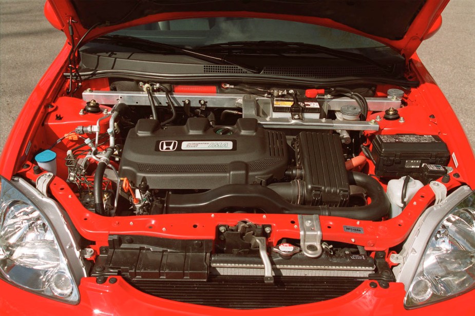 A view of the engine bay on a red Honda Insight.