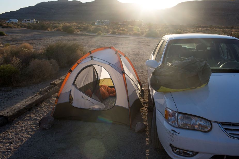 A road trip camper's tent and vehicle at the Mojave National Preserve in California