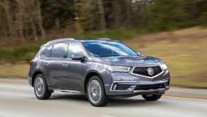 A gray 2017 Acura MDX Sport Hybrid midsize luxury crossover SUV model driving on a highway