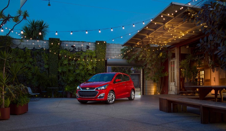 A red 2022 Chevy Spark sits outside a building.
