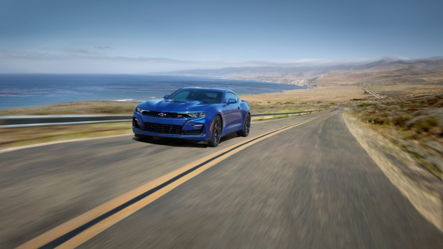A blue 2022 Chevy Camaro driving down a desert road.