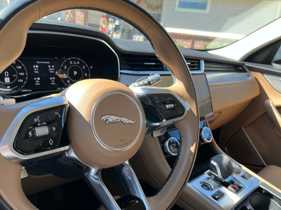 The steering wheel and center console view in the 2022 Jaguar F-Pace S.