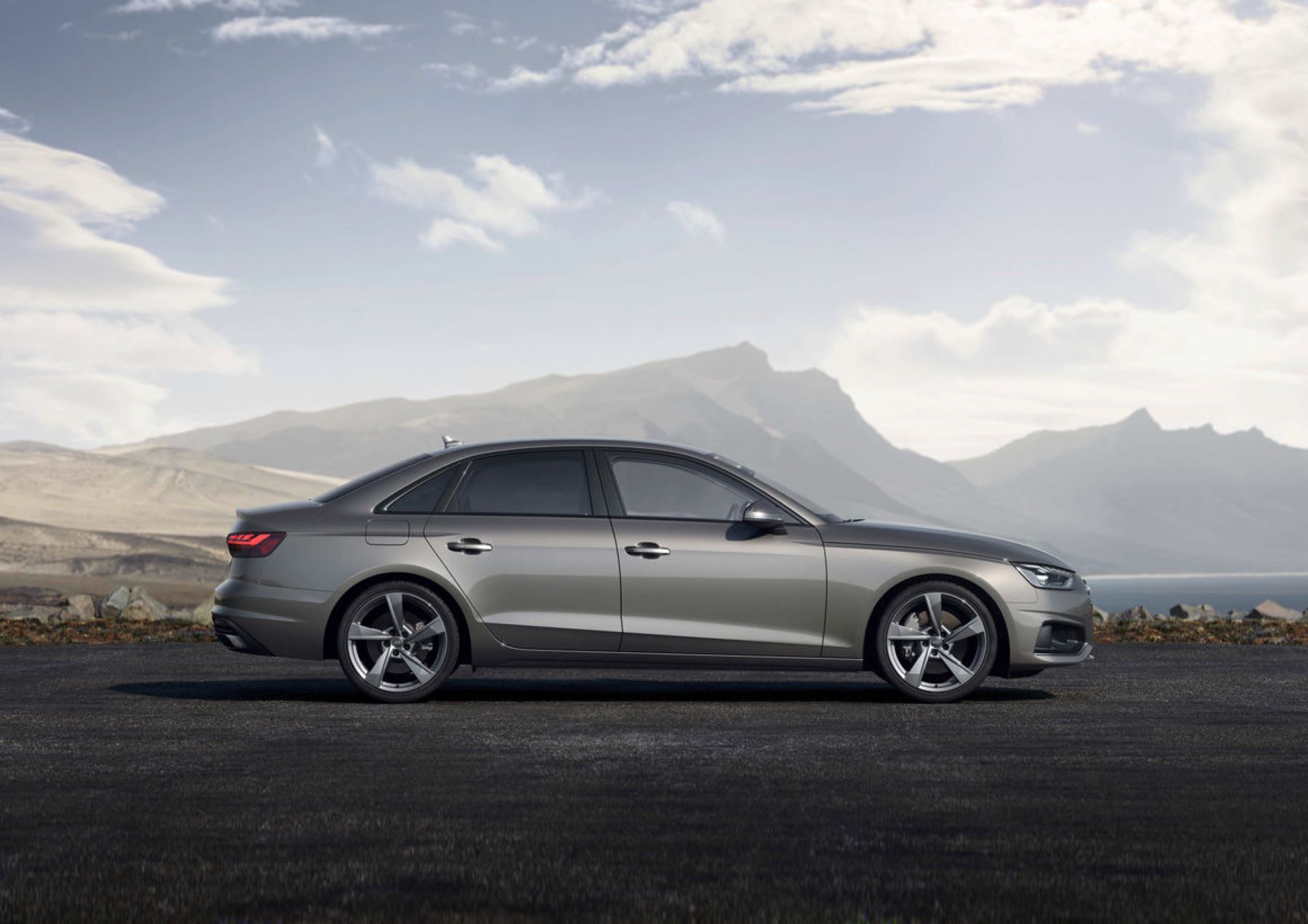 A side profile promotional shot of the 2022 Audi A4 luxury sedan near mountains covered in fog