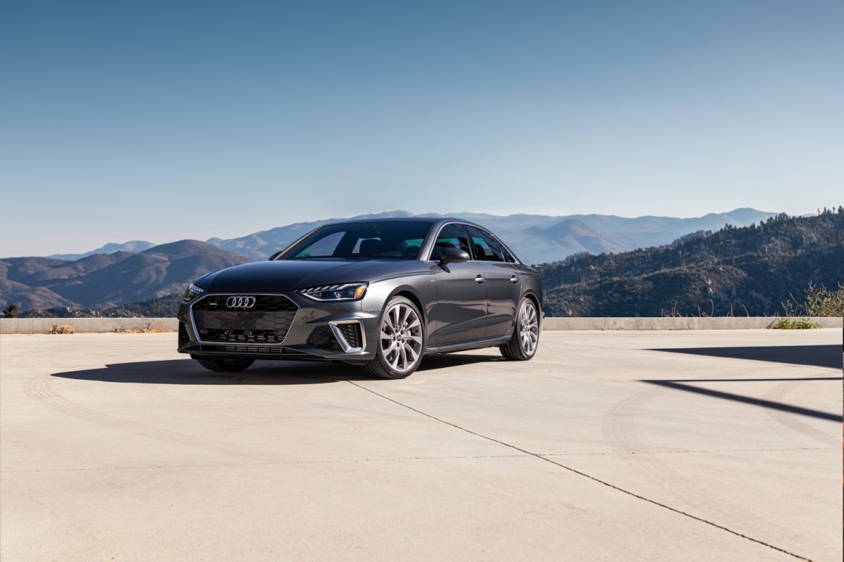 A dark grey 2022 Audi A4 parked in front of a mountain range