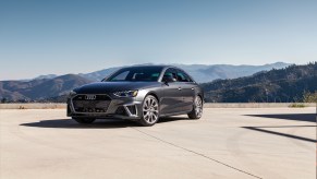 A dark grey 2022 Audi A4 parked in front of a mountain range