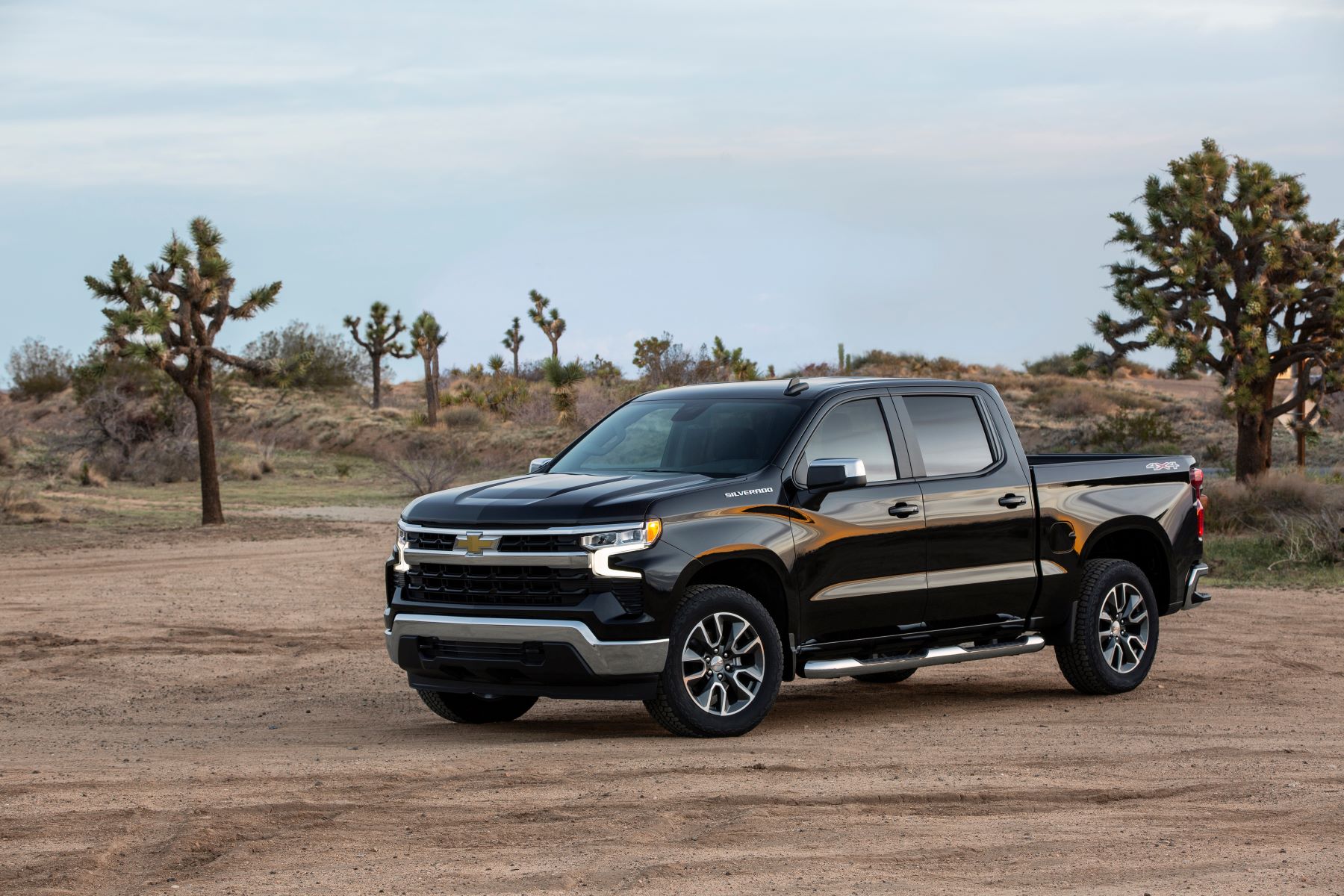 A black 2022 Chevrolet Silverado LT full-size pickup truck parked on a dirt plain in the desert