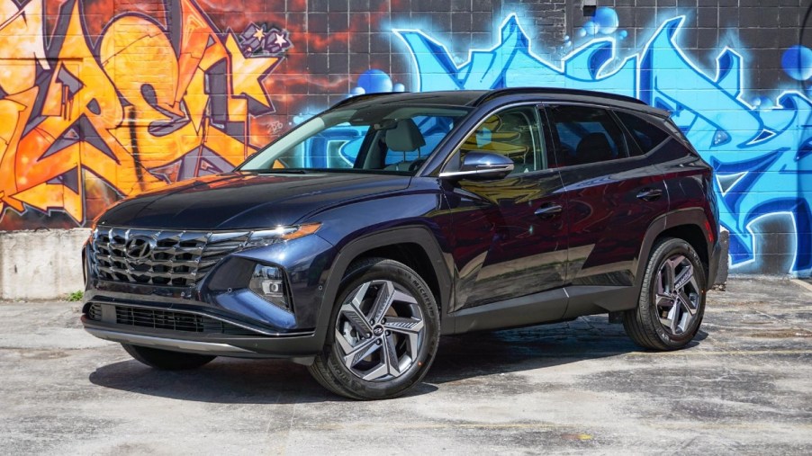 Blue 2022 Hyundai Tucson Hybrid with a Graffiti wall background