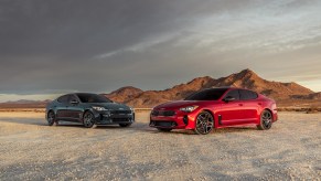A red and black 2022 Kia Stinger parked in the dessert.