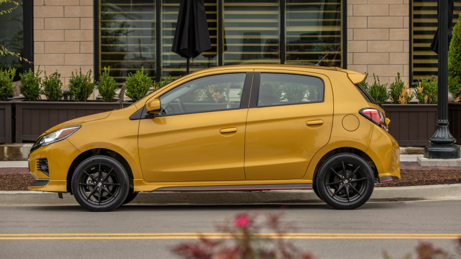 An orange 2022 Mitsubishi Mirage parked in front of a business, the Mirage is one of the cheapest new cars on the road today
