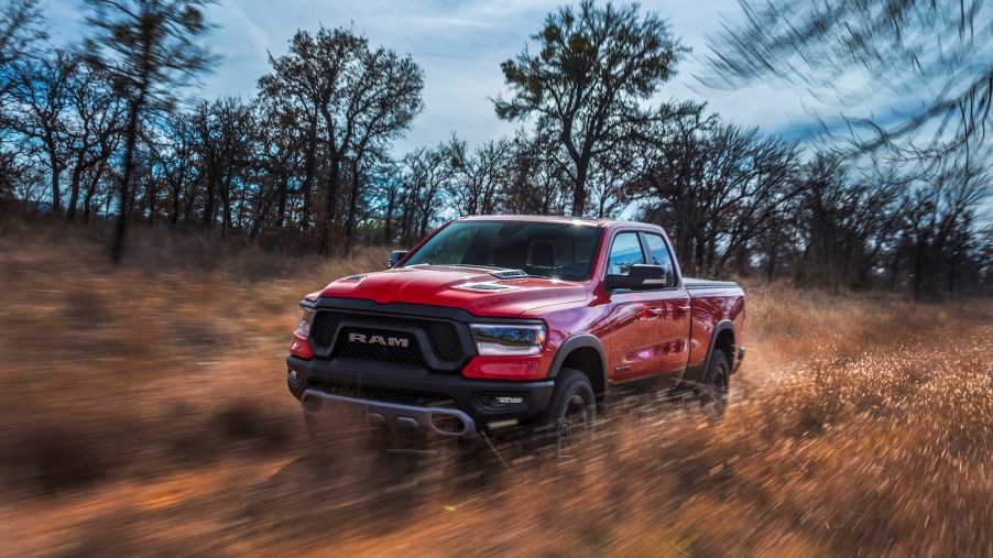 The Ram 1500 Rebel with TRX appearance package and a naturally-aspirated V8 in red, racing along an off-road trail.