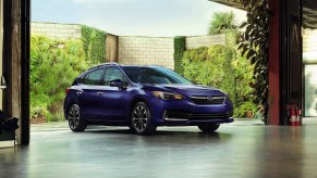 A blue 2022 Subaru Impreza parked outdoors near buildings.