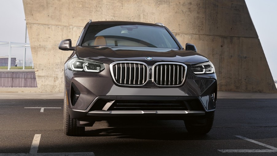 A gray 2023 BMW X3 luxury small SUV is driving on the road.