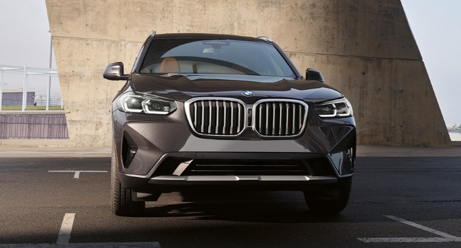 A gray 2023 BMW X3 luxury small SUV is driving on the road.