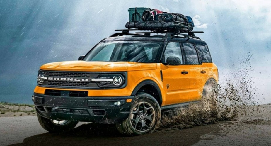 A yellow 2023 Ford Bronco Sport subcompact off-road SUV is driving off-road. 