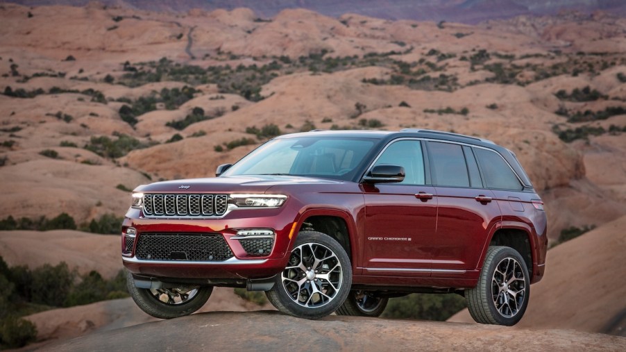 A red 2023 Jeep Grand Cherokee in a desert area.