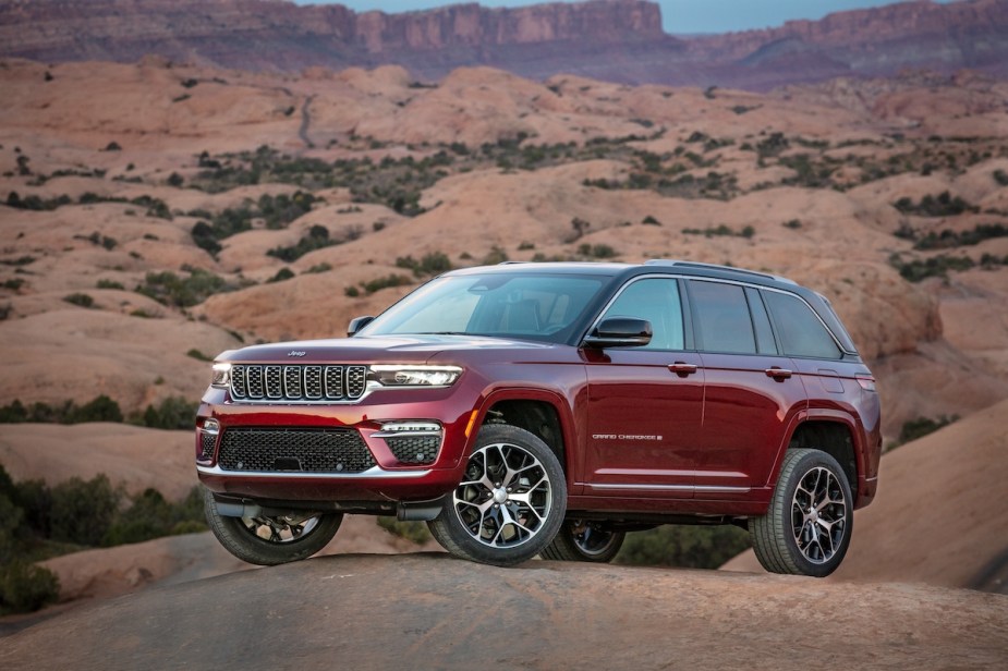 A red 2023 Jeep Grand Cherokee in a desert area.