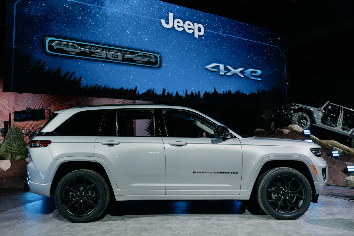 A white 2023 Jeep Grand Cherokee parked indoors.