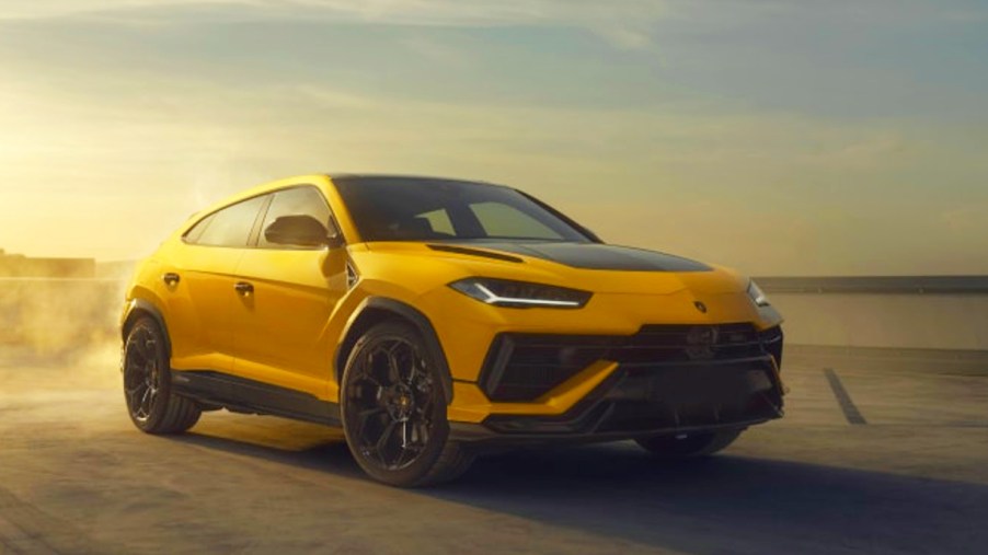 A yellow 2023 Lamborghini Urus Performante is driving on the road.