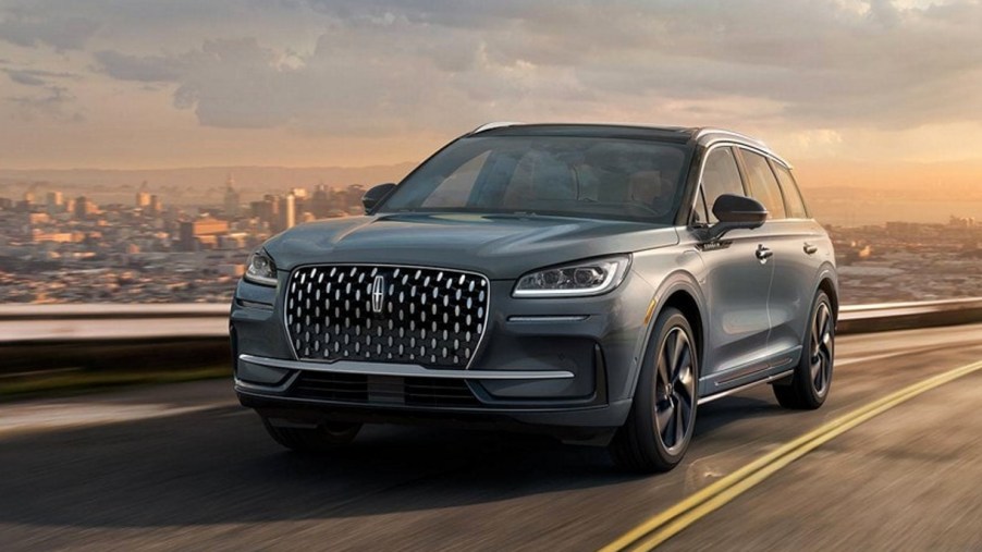 A gray 2023 Lincoln Corsair small luxury SUV is driving on the road.