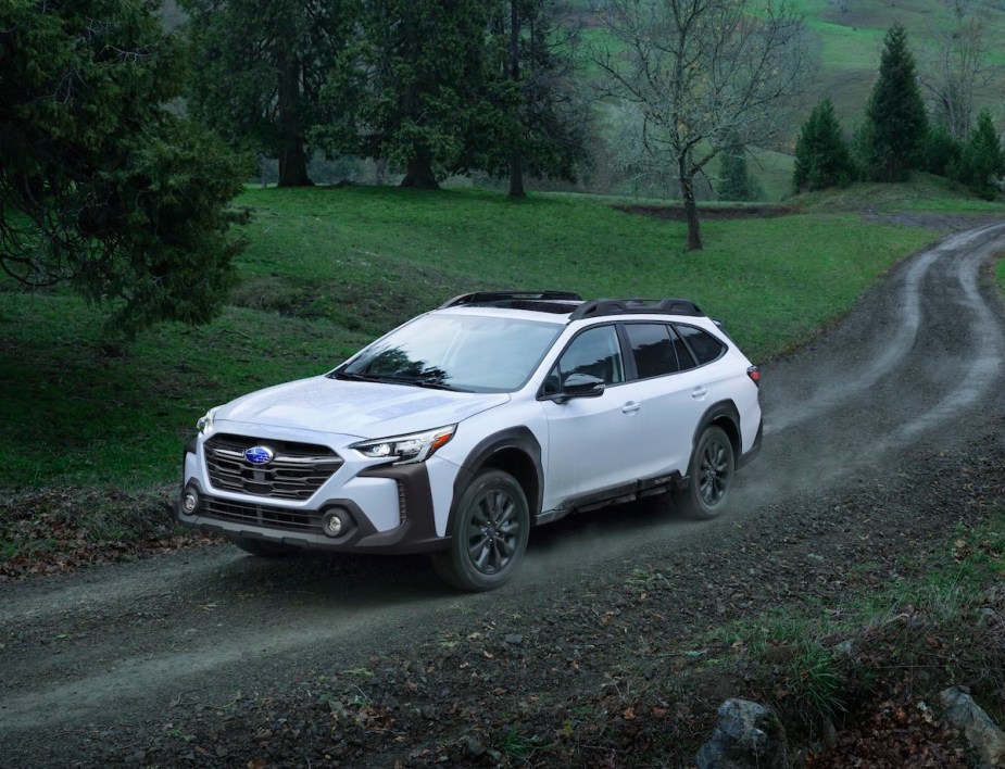 A white 2023 Subaru Outback driving down a road.