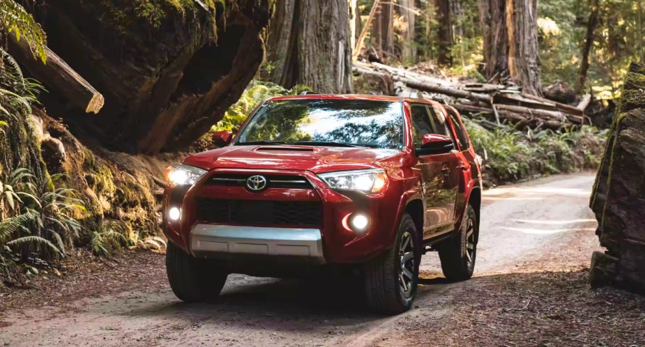 A red 2023 Toyota 4Runner midsize SUV is driving off-road. 