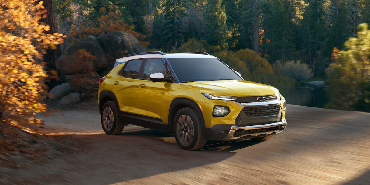 A yellow 2023 Chevy Trailblazer parked outside on a nature trail. Is it bigger than the Chevy Equinox?