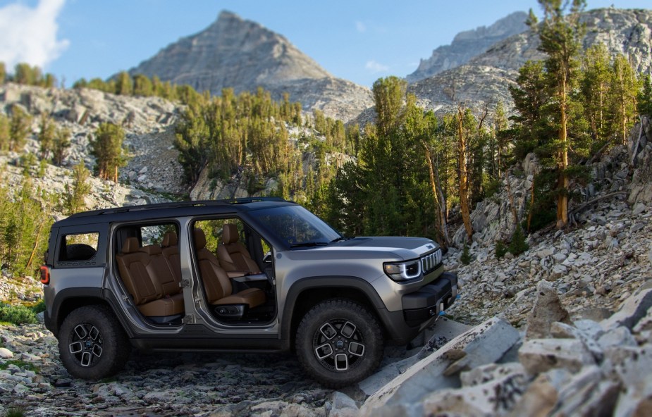 The new Jeep Recon electric SUV, with its doors removed, parked on an off-roading trail in the mountains.