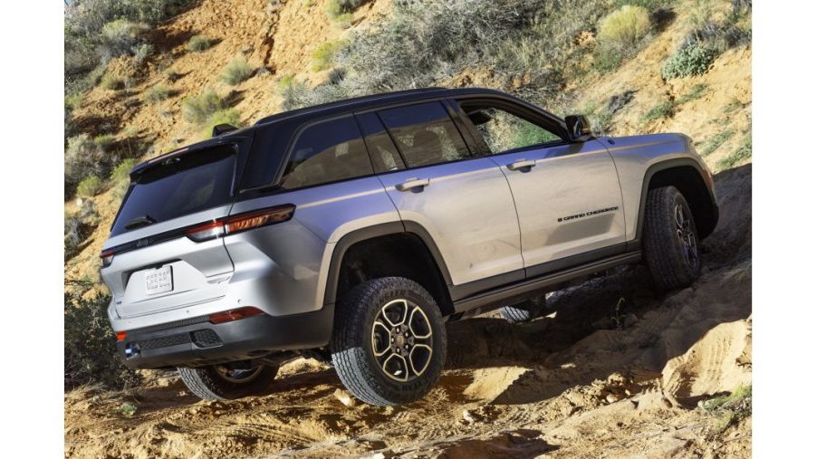 A silver Jeep Grand Cherokee 4xe Trailhawk on dirt.