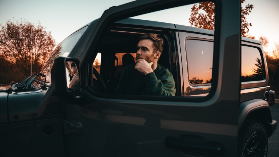 Bearded man sitting in an SUV, highlighting why people sit in parked cars for a long time