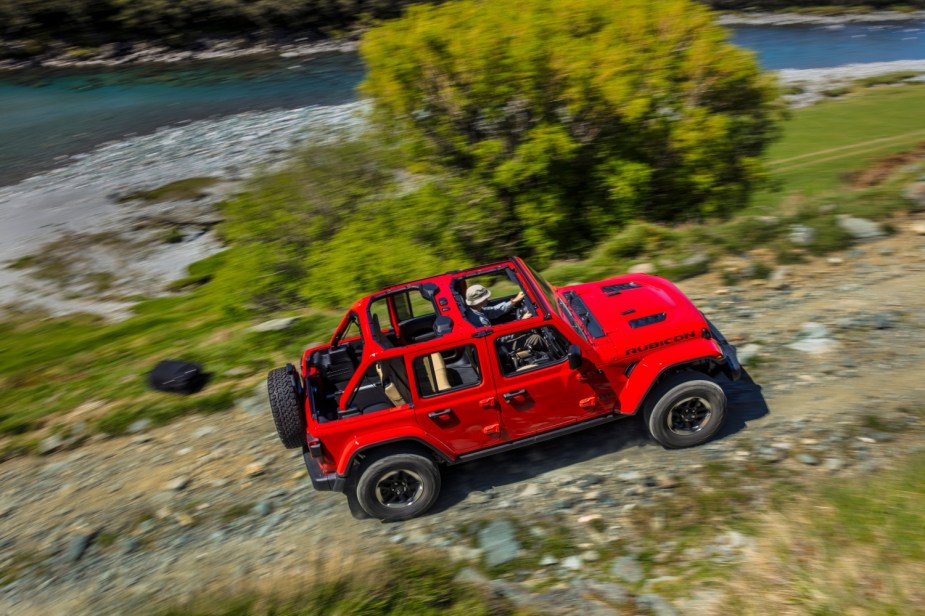 The 2022 Jeep Wrangler Rubicon in red driving. Unlimited Wranglers are four-door SUVs instead of two-door.
