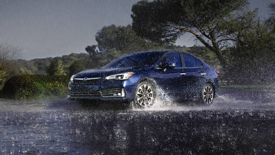 Blue 2023 Subaru Impreza, the only new car with AWD that costs under $20,000, driving in rain