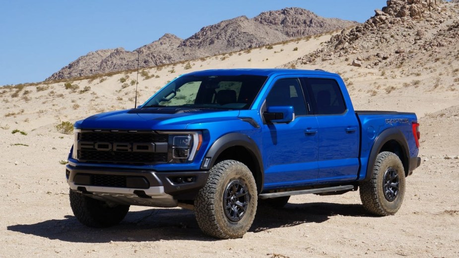 Blue Ford F-150 Raptor Half-Ton Truck posed on the desert, it features standard 4WD.