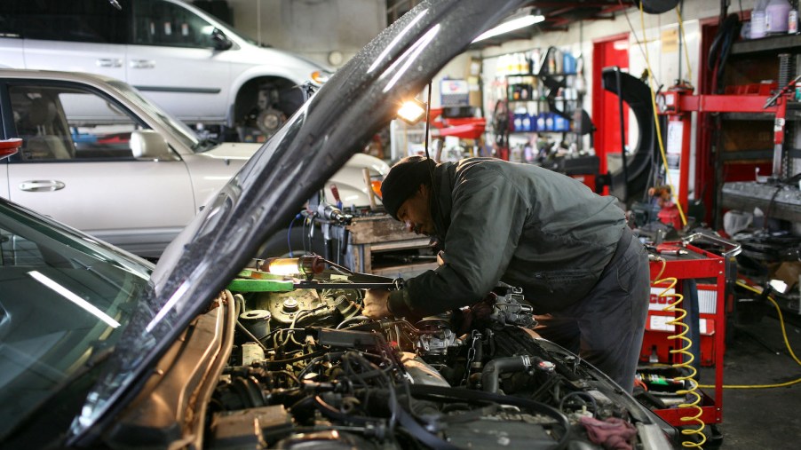 A man repairing a car, likely after the check engine light came on
