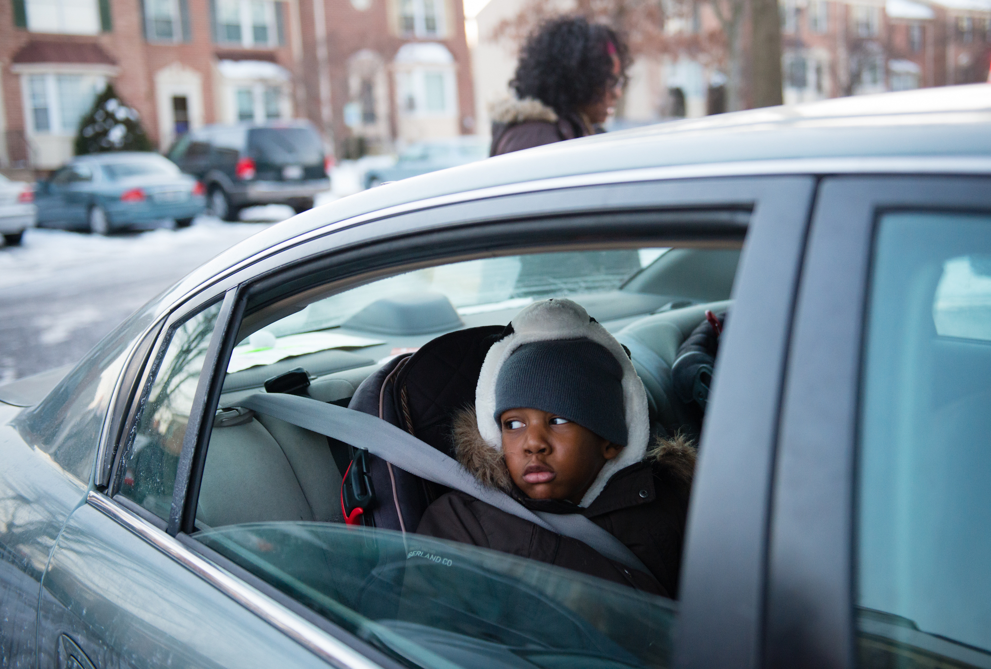A person looking out of a open car window that may be subject to wind buffeting.