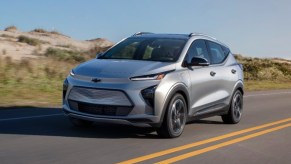 A gray Chevy Bolt EUV subcompact electric SUV is driving on the road.