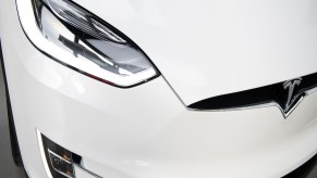 An EV turning signal and headlight, which the turn signals affect an EV's driving range, on a white Tesla.