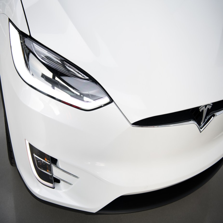 An EV turning signal and headlight, which the turn signals affect an EV's driving range, on a white Tesla. 